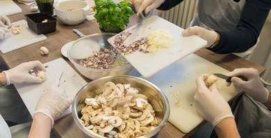 Foto: Gemeinsames Kochen in der Tagesklinik. Man sieht die Hände beim Schnippeln.