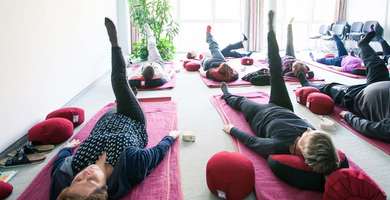 Foto: Eine Turnhalle: Patienten liegen auf Matten und führen gymnastische Übungen aus.